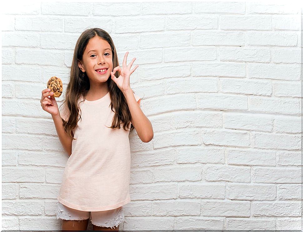 Girl receiving a cookie as positive reinforcement for her good behavior.