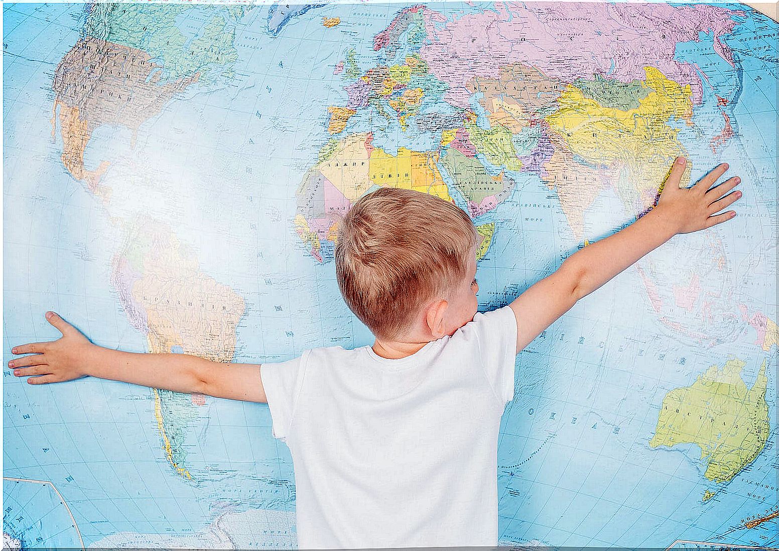 Child hugging a children's world map.