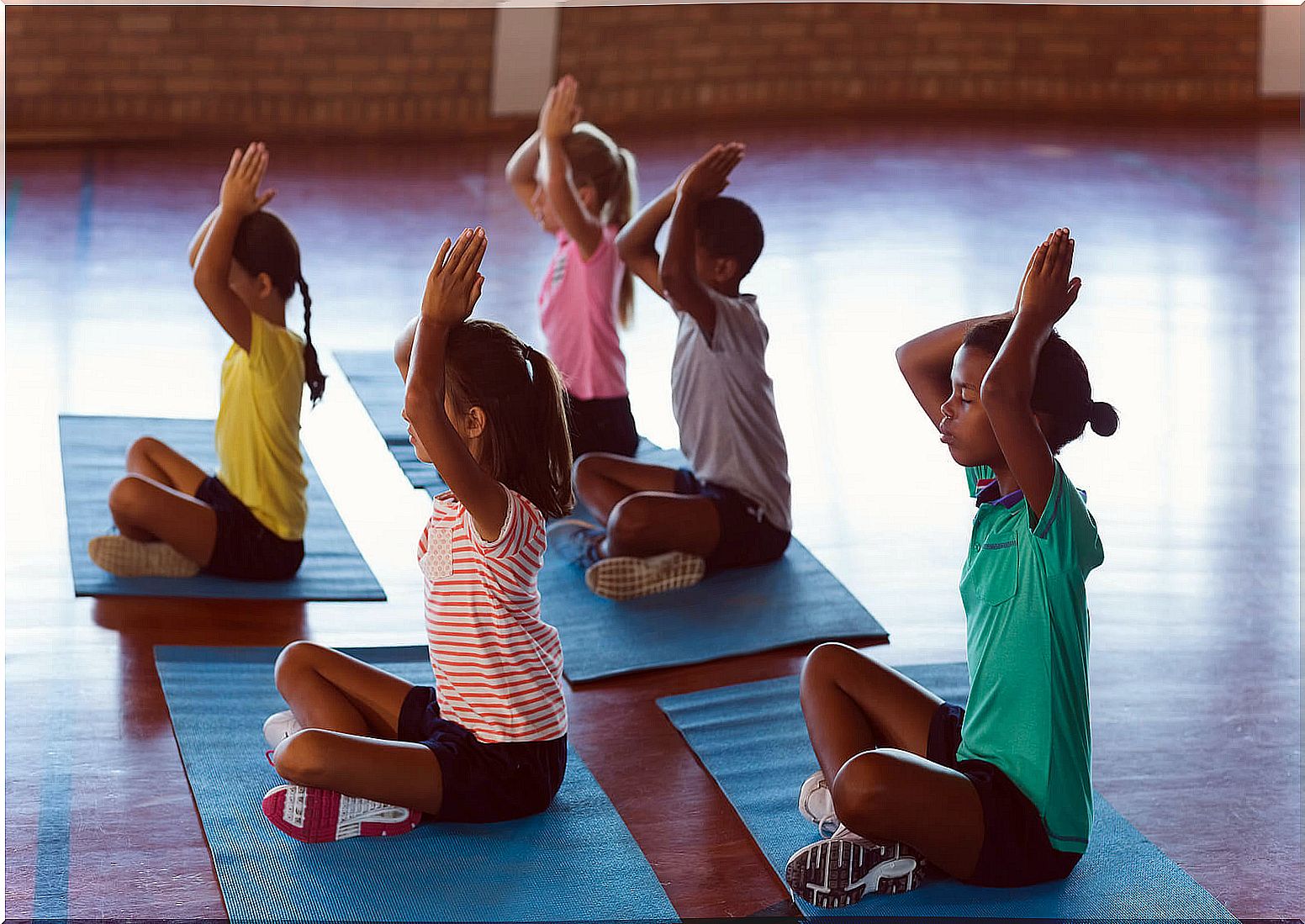 Children practicing yoga to reduce stress.
