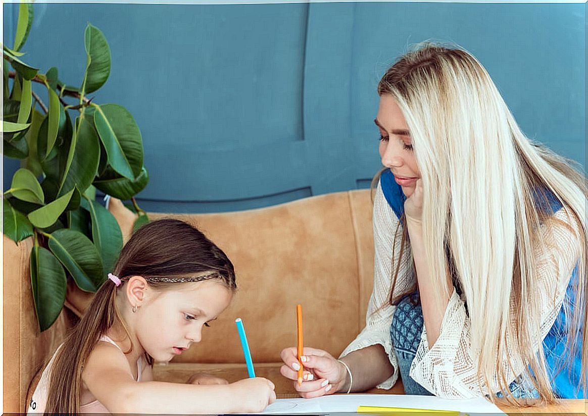 Little girl drawing a picture with her mother.
