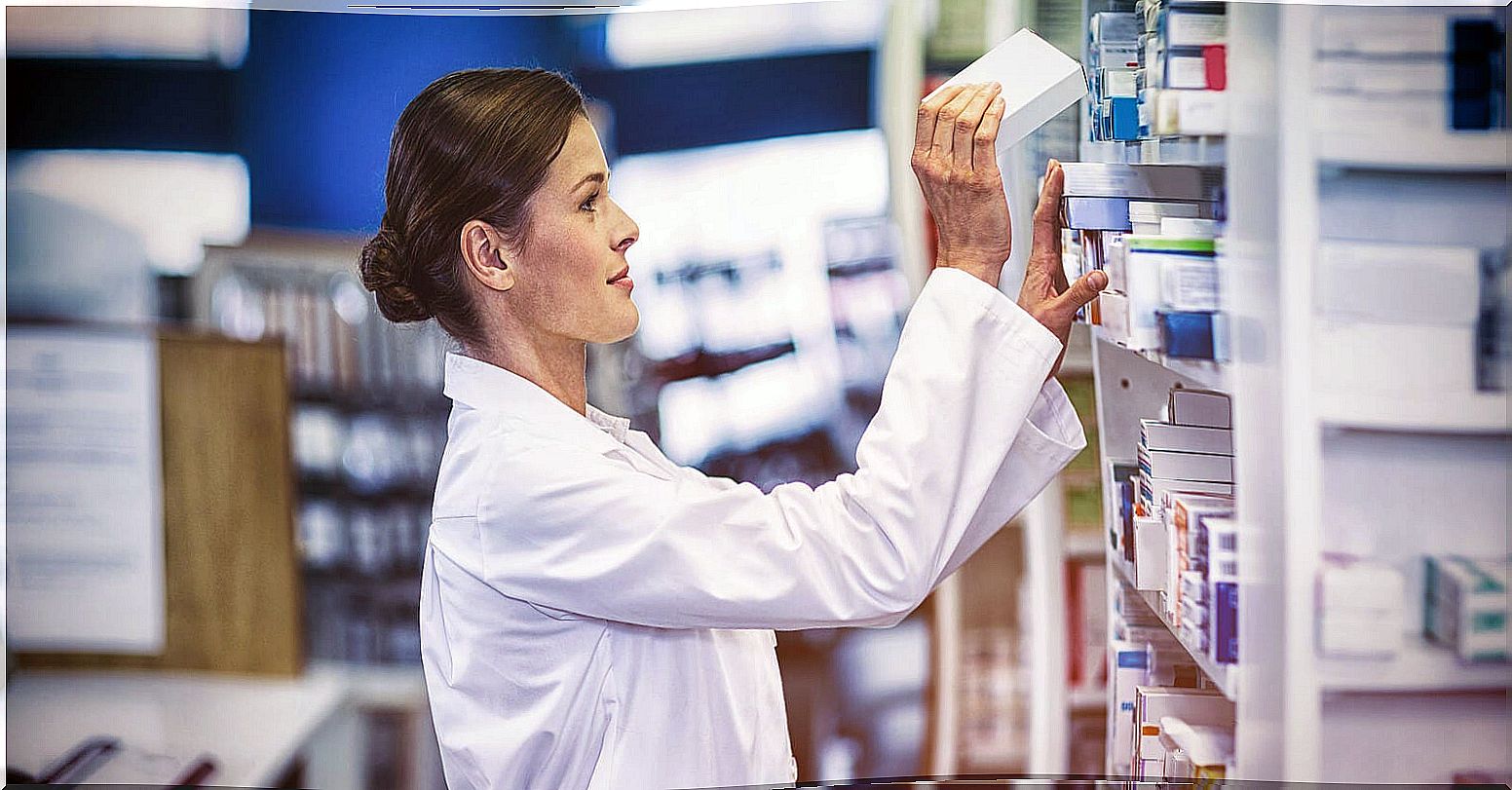 Pharmacist picking up a box of antibiotics.